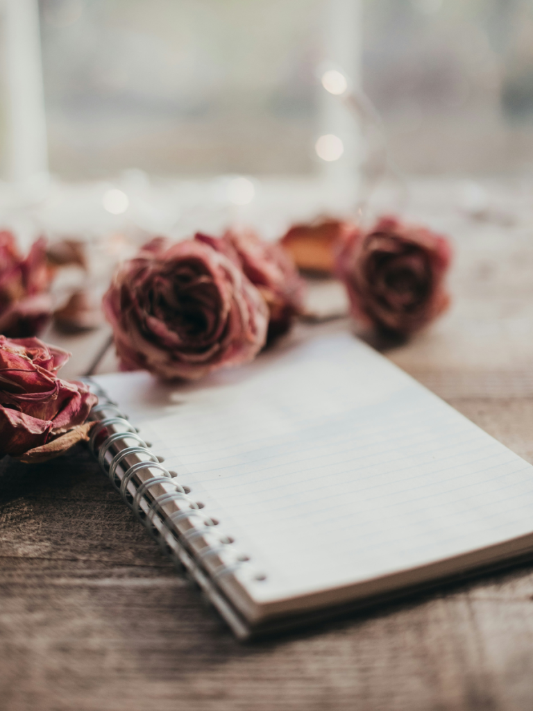 a blank notebook among roses