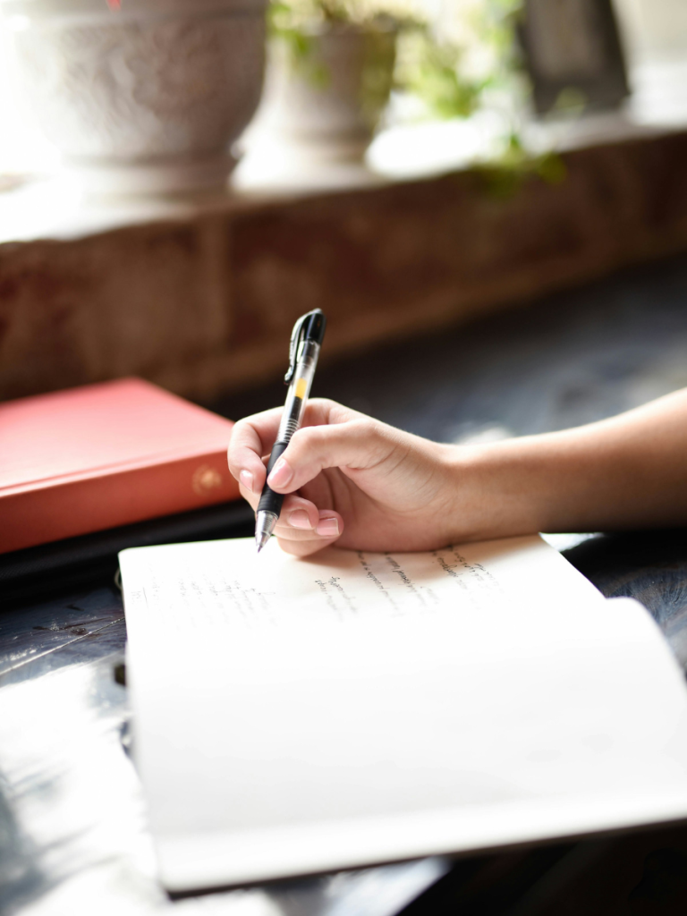 writing in a notebook with a pen