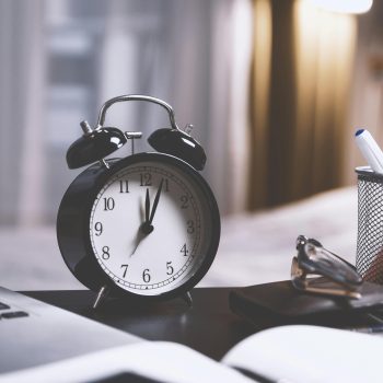 alarm clock on writing desk - find time for writing